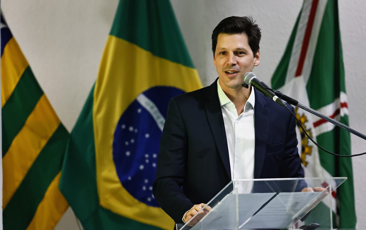 Daniel Vilela, usando um blazer preto e camisa de manga longa branca, em cima de um púlpito de acrílico, discursando no lançamento da Rede Nascer em Goiás. Atrás dele, estão as bandeiras do Brasil, do estado de Goiás e da cidade de Goiânia.
